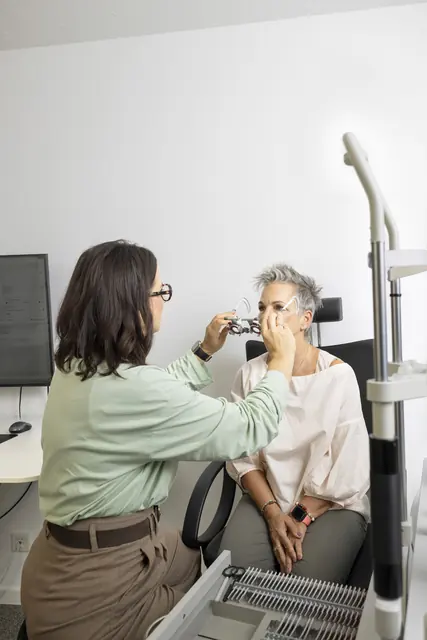 Optikerin setzt einer Kundin die Messbrille auf