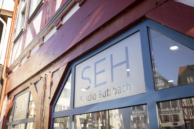 Schaufenster mit dem Schriftzug des Fachgeschäfts am roten Fachwerk